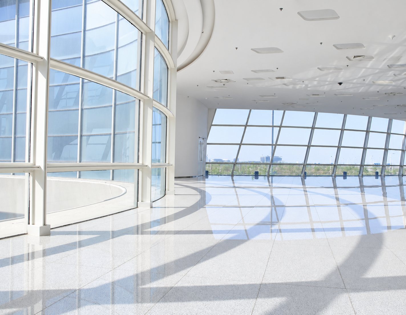 Espace lumineux : hall moderne avec baies vitrées et sol blanc